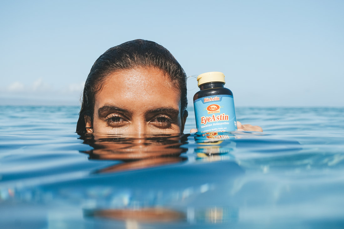 SURFER GIRL HOLDING PRODUCT IN THE WATER FOR PRODUCT PHOTOGRAPHY