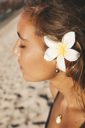 BEAUTIFUL LADY WEARING FLOWER IN HER EAR POSING FOR A JEWELRY COMMERCIAL IN HAWAII